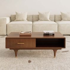 a coffee table sitting on top of a carpeted floor next to a white couch