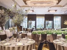 a banquet room set up with round tables and floral centerpieces