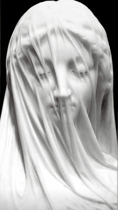 a black and white photo of a woman's face covered in veils with her eyes closed