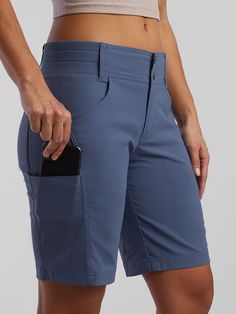 a woman in blue shorts holding a cell phone