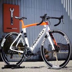 a white and orange bike parked in front of a building