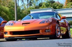 two orange sports cars parked next to each other