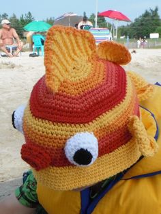 a child wearing a crocheted hat on the beach