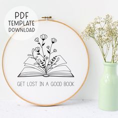 a cross stitch book with flowers on it and the words get lost in a good book