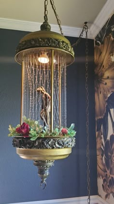 a chandelier hanging from the ceiling in a room with blue walls and floral wallpaper