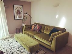 a green couch and ottoman in a living room