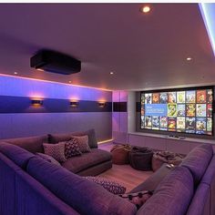 a purple couch sitting in front of a flat screen tv mounted to the side of a wall