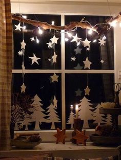 the window is decorated with christmas lights and stars on it's windowsills