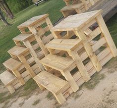 a group of wooden benches sitting next to each other on top of a grass covered field