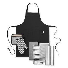 an apron, oven mitts and dish cloths are laid out on a white background