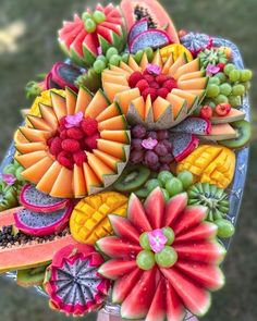 a bunch of fruits and vegetables are arranged in the shape of a bouquet on a plate