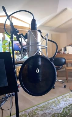 a microphone in front of a table with chairs and a laptop computer on top of it