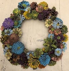 a wreath made out of pine cones and flowers