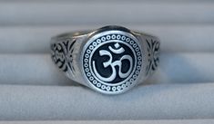 This ring was designed with the Om Ohm symbol. Symbol of oneness in Hinduism and other world religions.  As seized in the West, the Om symbol marks content dealing with yoga, spirituality, and the feelings of inner peace. The beautiful pewter ring is a silver color and the background is blackened to bring out the fine detail of the design. Our rings are 100% Lead and nickel free pewter and made in the USA The top design part of the ring measures about 15 mm in diameter The ring band tapers from about 15mm to about 4.5mm at the bottom and is about 1.75mm thick We offer free shipping within the USA Rings are available in sizes 7 to 14 Adjustable Hallmarked Spiritual Signet Ring, Ohm Ring, Saturn Symbol, Om Jewelry, The Om Symbol, Ohm Symbol, Yoga Spirituality, Yoga Ring, Pewter Ring