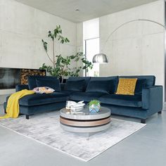 a living room with blue couches and a white rug on the floor in front of a fireplace