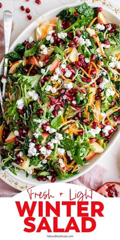 a salad with pomegranate, carrots and feta cheese on top