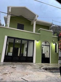 a green house with black doors and windows