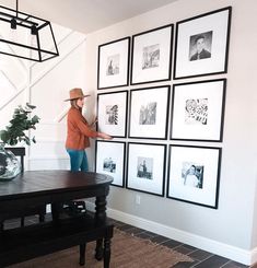 a woman standing in front of a wall with pictures on it