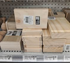 several pieces of wood stacked on top of each other in a store shelf with price tags