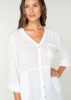 A classic lightweight button-front tunic shirt with side pockets. FINAL SALE Tunic shirt Relaxed, oversize fit Long rolled sleeve with button tab closure Banded collar V-neckline Button front Side pockets Sheer Classic bohemian shirt A must-have addition to any woman's wardrobe, this lightweight shirt adds an effortless laid back feel to any outfit. Featuring long rolled sleeves with a button tab closure, side pockets, and a long tunic length. Throw it on over your swimsuit at the beach, or wear V-neck Shirt With Button Closure For Beach, Layering Button-up Shirt With Pockets, Effortless Long Sleeve Beach Blouse, Relaxed Fit Beach Tops With Placket, Relaxed Long Sleeve Beach Shirt, Effortless Long Sleeve Blouse For Beach, Spring Beach Top With Placket, Spring Shirt With Button Cuffs For Layering, Spring Layering Shirt With Button Cuffs