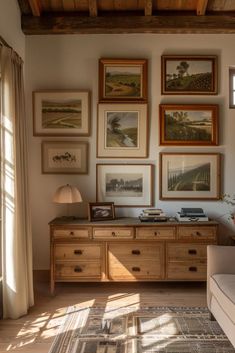 a living room filled with furniture and framed pictures on the wall above it's coffee table