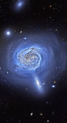 two spiral galaxy like objects in the night sky with stars around them and one large blue object