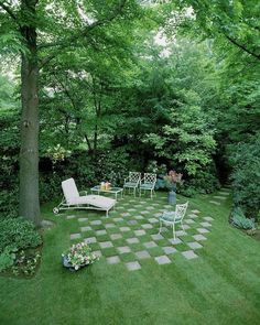 a garden with lawn furniture and trees in the background