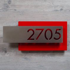 a red and silver metal name plate with the number seventy5 on it's side