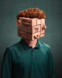 a man wearing a cardboard head made to look like a cube with hair on it