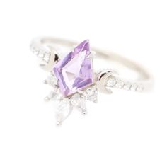 A gem of lavender Quartz shines in a sky of diamonds. Befitting a galactic princess, the Veronica Ring features a mesmerizing Lavender Quartz center stone framed with lunar accents and an arrangement of shimmering white cubic zirconia accent stones. Another series of accent stones line the ring on each side, adding ext Lavender Fine Jewelry With Diamond Accents, Lavender Amethyst Cubic Zirconia Ring, Lavender Amethyst Ring In Cubic Zirconia, Lavender Amethyst Jewelry With Diamond Accents, Wedding Amethyst Diamond Ring With Accents, Wedding Amethyst Diamond Ring With Diamond Accents, Luxury Lavender Wedding Jewelry, Luxury Lavender Jewelry For Wedding, Purple Rose Cut Diamond Ring