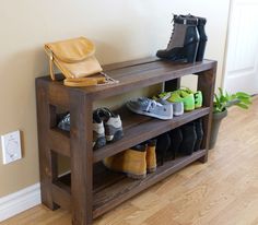 there is a shoe rack with many pairs of shoes on it and a bag next to it