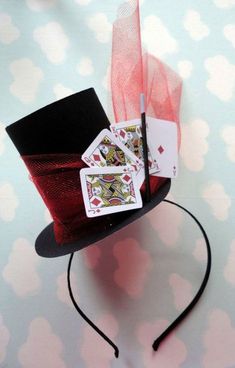 a top hat with playing cards on it and a pen sticking out of the side