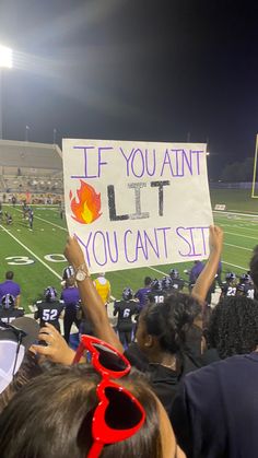 people holding up signs at a football game