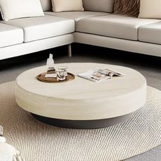 a living room with white couches and a round coffee table