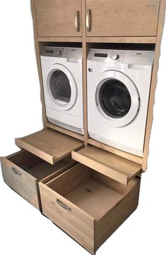 an open washer and dryer sitting next to each other in a wooden cabinet