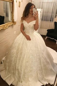 a woman is taking a selfie in her wedding dress while wearing a white gown