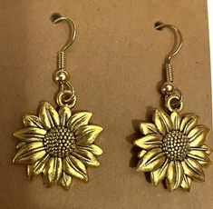 They are 1 sided in gold finish pewter.  They hang 3/4" long on gold finish wires. FREE SHIPPING IN THE USA Sunflower Earrings, Gold Gold, Gold Finish, Jewelry Earrings Dangle, Dangle Drop Earrings, Beauty Book, Sunflower, Dangle Earrings, Etsy Accessories