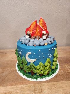 there is a blue cake with fire and rocks on it