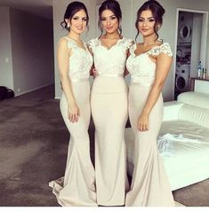 three beautiful women standing next to each other in front of a white couch and bed