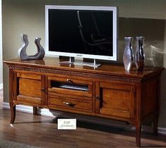 a flat screen tv sitting on top of a wooden entertainment center