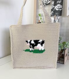 a white bag with a black and white cow on it sitting on top of a table