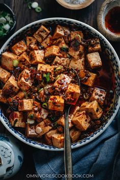 tofu in a blue and white bowl with chopsticks