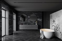 an elegant bathroom with black marble walls and flooring, round mirror above the bathtub