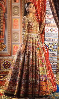 a woman standing in front of a curtain wearing a colorful dress and headpieces