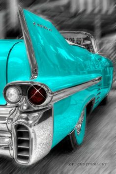 an old blue car parked on the side of the road with its hood up in black and white