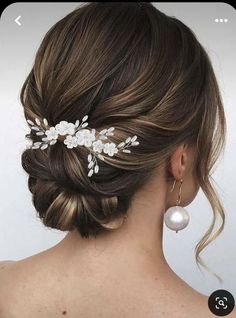 a woman wearing a hair comb with flowers and pearls on it's head,