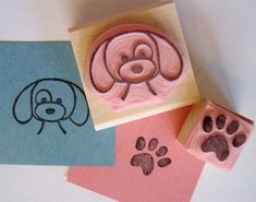 a rubber stamp with a dog's face and paw prints on it, next to some stamps