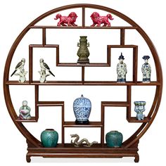 a circular shelf with vases and figurines on it's sides in front of a white background