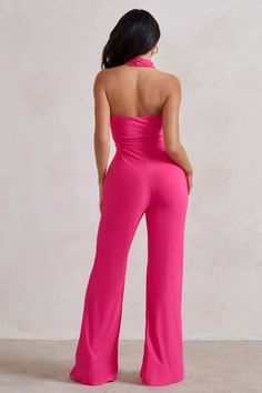 a woman in pink jumpsuits looking down at the back of her bodysuit