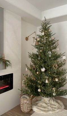 a small christmas tree in a living room next to a fire place with ornaments on it